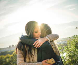 Woman hugs friend as she makes amends in her addiction recovery journey