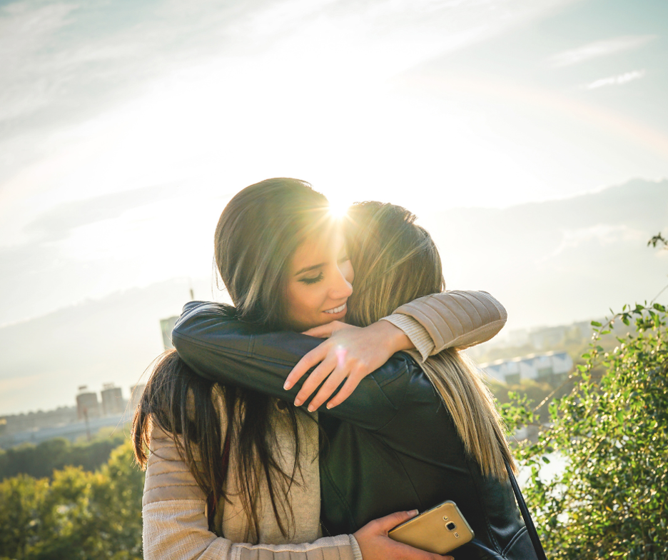 Woman hugs friend as she makes amends in her addiction recovery journey